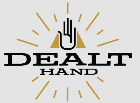The Dealt Hand Logo. The minimalistic logo features a shining gold triangle with a hand in front of it. Under the hand reads "Dealt Hand" in a stylized font.
